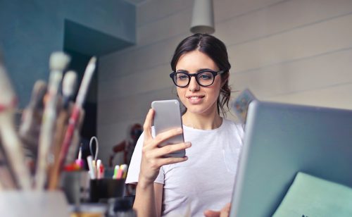 female business owner looking at a phone- Brand Strategy for Resilient Businesses